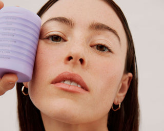 woman taking selfie with the makeup stack next to her face