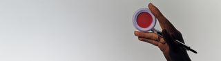 Hand holding a stak pan and a lip brush