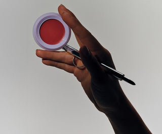 Hand holding a stak pan and a lip brush