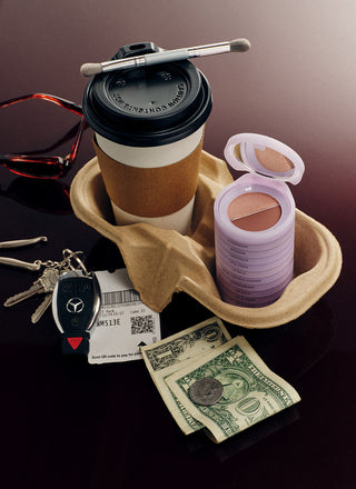 makeup stack in a coffee carrying caddy next to a coffee